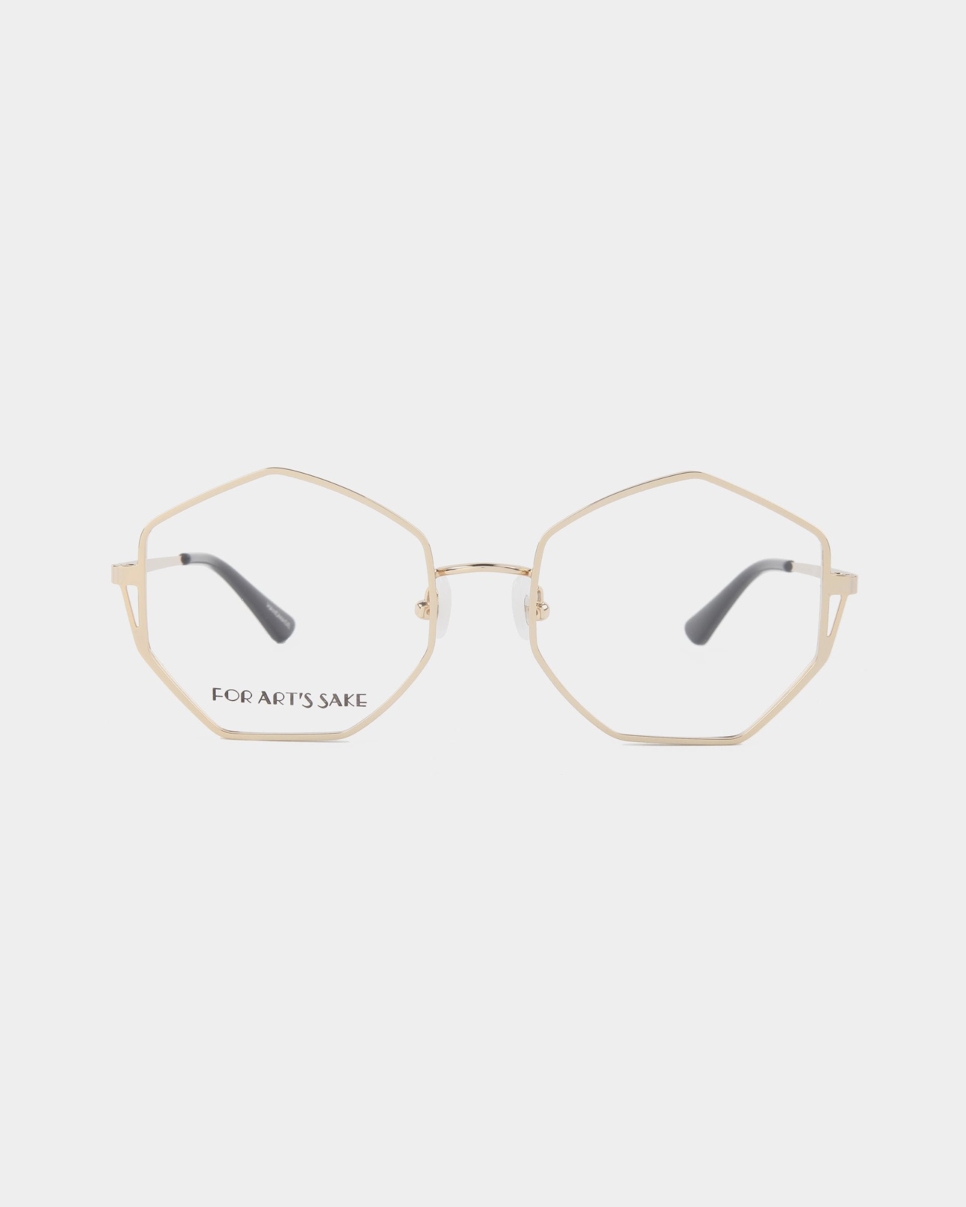 The Antidote by For Art's Sake® is a pair of eyeglasses with geometric, 18-karat gold-plated stainless steel frames and transparent lenses. The temples are adorned with black tips for added comfort.