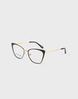 A pair of stylish Stella Two eyeglasses by For Art's Sake® with a black cat-eye frame and 14kt gold plated arms. The lenses are clear, and the tips of the arms are black. The brand name is visible on the inside of the left lens. Prescription services available. The background is white.