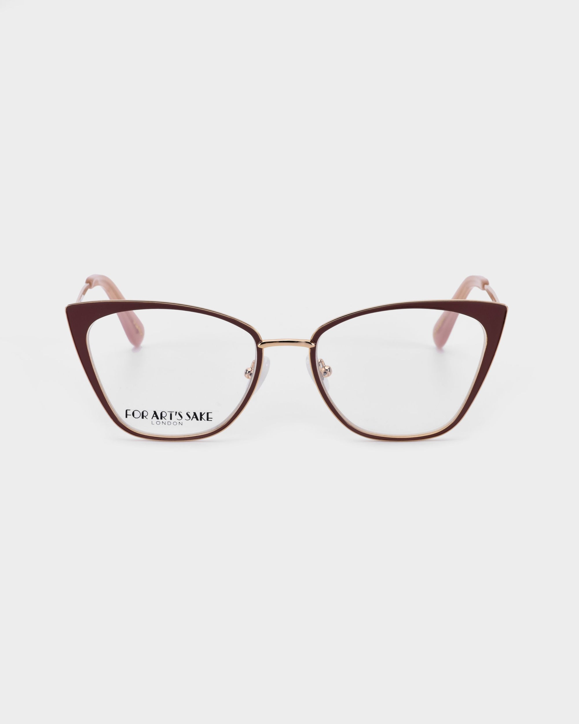 Introducing the Stella Two: a pair of stylish cat-eye glasses featuring a brown frame with 14kt gold-plated accents. The glasses have Blue Light Filter clear lenses and pink arm tips. The brand name &quot;For Art&#39;s Sake®&quot; is visible on the inside of the right lens, set against a plain white background.