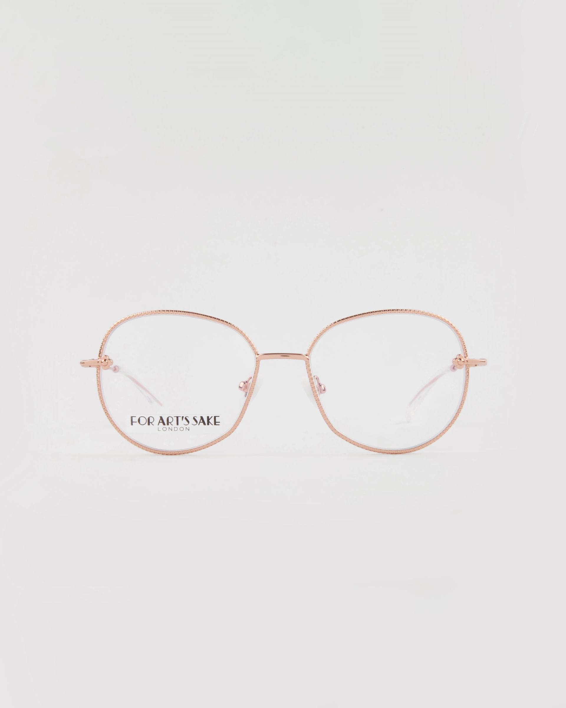 A pair of gold-plated stainless steel eyeglasses with round clear lenses. The glasses have thin gold temples and a lightweight design. The brand name &quot;For Art&#39;s Sake®&quot; and &quot;LONDON&quot; are printed on the left lens. This handmade Jasmine eyewear features a white, clean background for showcasing elegance.