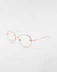 A pair of Jasmine eyeglasses by For Art's Sake® with a thin and delicate frame is displayed against a white background. The handmade eyewear boasts ovoid lenses, clear nose pads, and a minimalist, elegant design. Crafted from gold-plated stainless steel, the arms are straight with a slight curve at the ends.