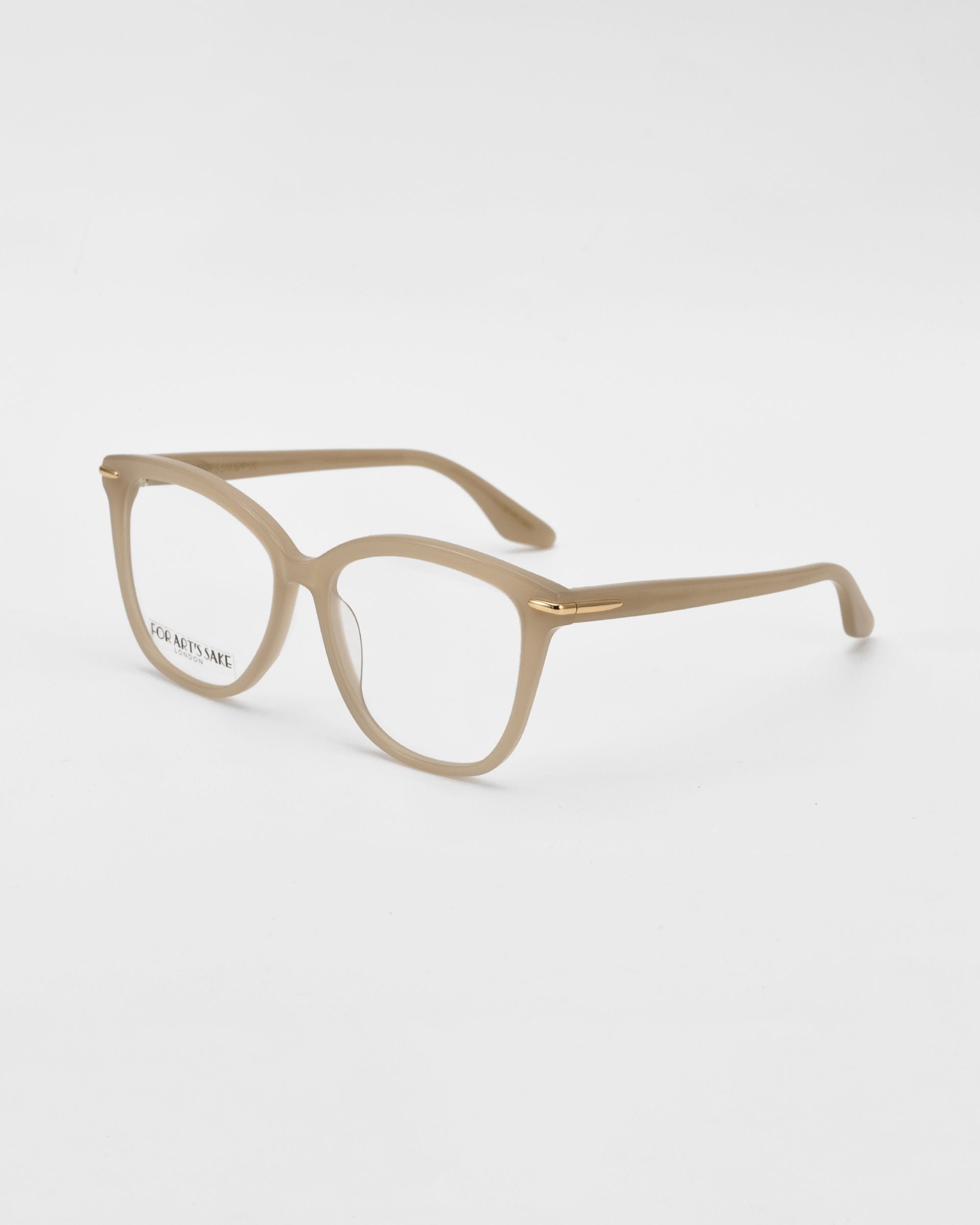 A pair of beige prescription eyeglasses with rectangular frames, crafted by For Art&#39;s Sake® Cadenza, and the text &quot;FOR ART&#39;S SAKE&quot; visible on the inside of the right lens, set against a plain white background.