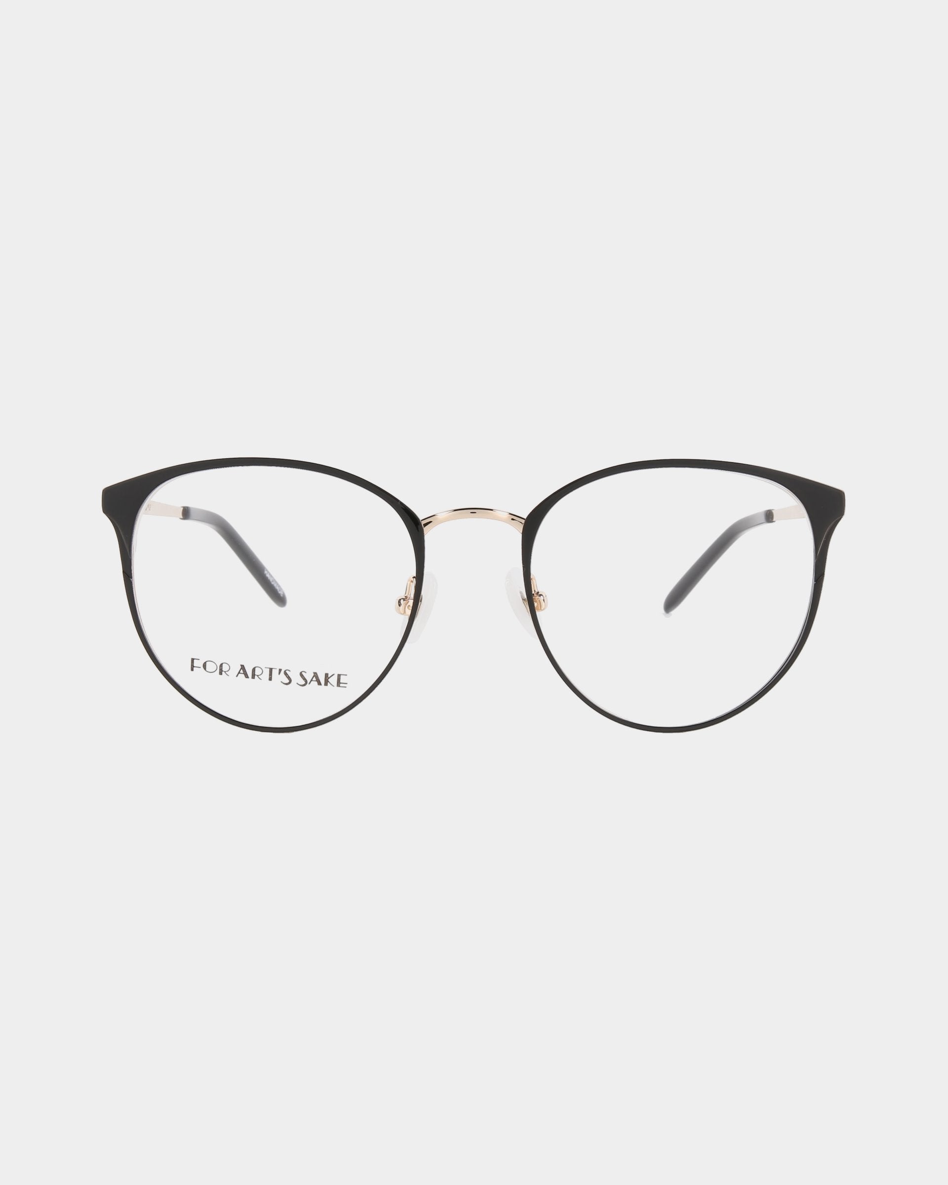 A pair of thin-rimmed, round eyeglasses with black and gold frames is displayed against a white background. The left lens includes the text "For Art's Sake." The design is simple and elegant, featuring blue light filter lenses to protect your eyes from digital strain. These eyeglasses are the Olivia by For Art's Sake®.