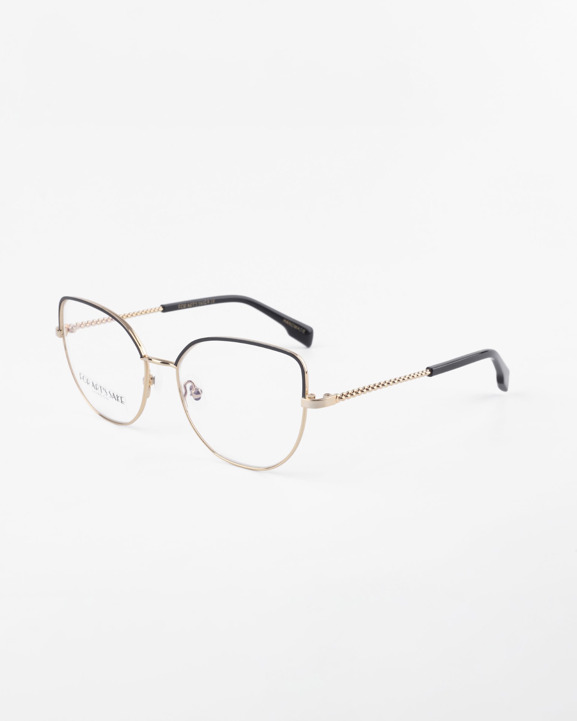 A pair of Ophelia by For Art's Sake® eyeglasses with a gold-colored frame and black earpieces. The frame features a subtle chain-like design on the temples, and the clear lenses come with a blue light filter. The glasses are set against a plain white background.