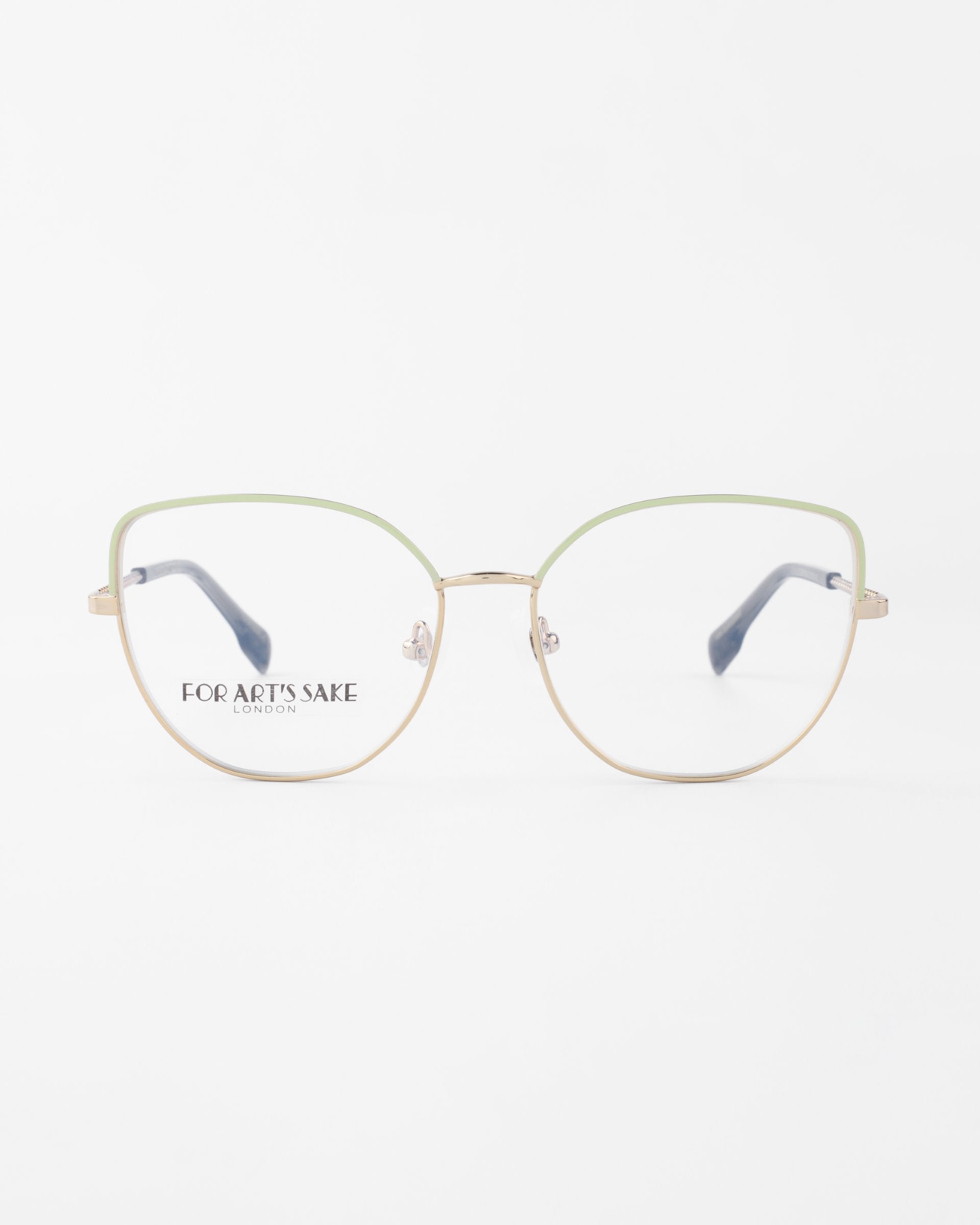 A pair of **Ophelia** eyeglasses with thin, gold metal frames and green accents around the lenses. Featuring a subtle cat-eye silhouette, the clear lenses carry the brand &quot;**For Art&#39;s Sake®**&quot; on the inside of the left lens. The glasses are set against a plain white background.