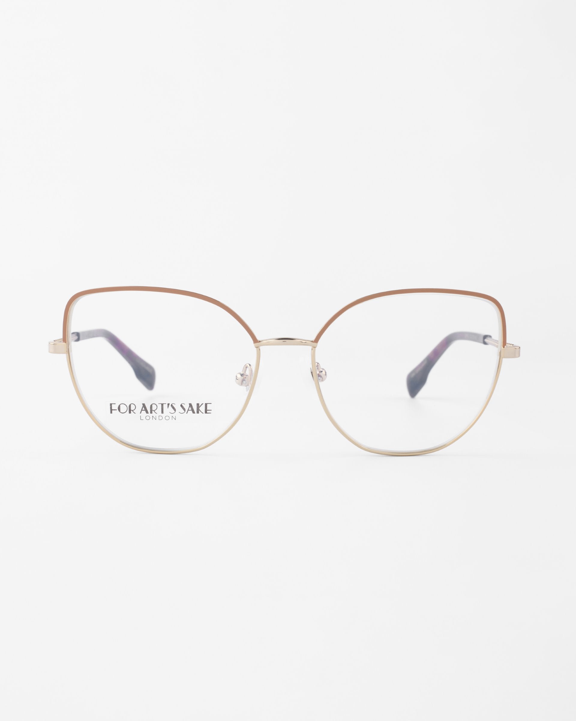 A pair of stylish, round eyeglasses with slender gold frames and brown-tinted upper rims. The clear lenses, featuring a slight cat-eye silhouette, come with a blue light filter. "For Art's Sake® Ophelia" is printed on the inside of the left lens. The background is plain white.