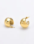 A pair of small, polished 24k gold Orbit Earrings Gold from For Art's Sake® is displayed against a plain white background. The earrings have a thick, rounded design and are slightly open with post-back closures.