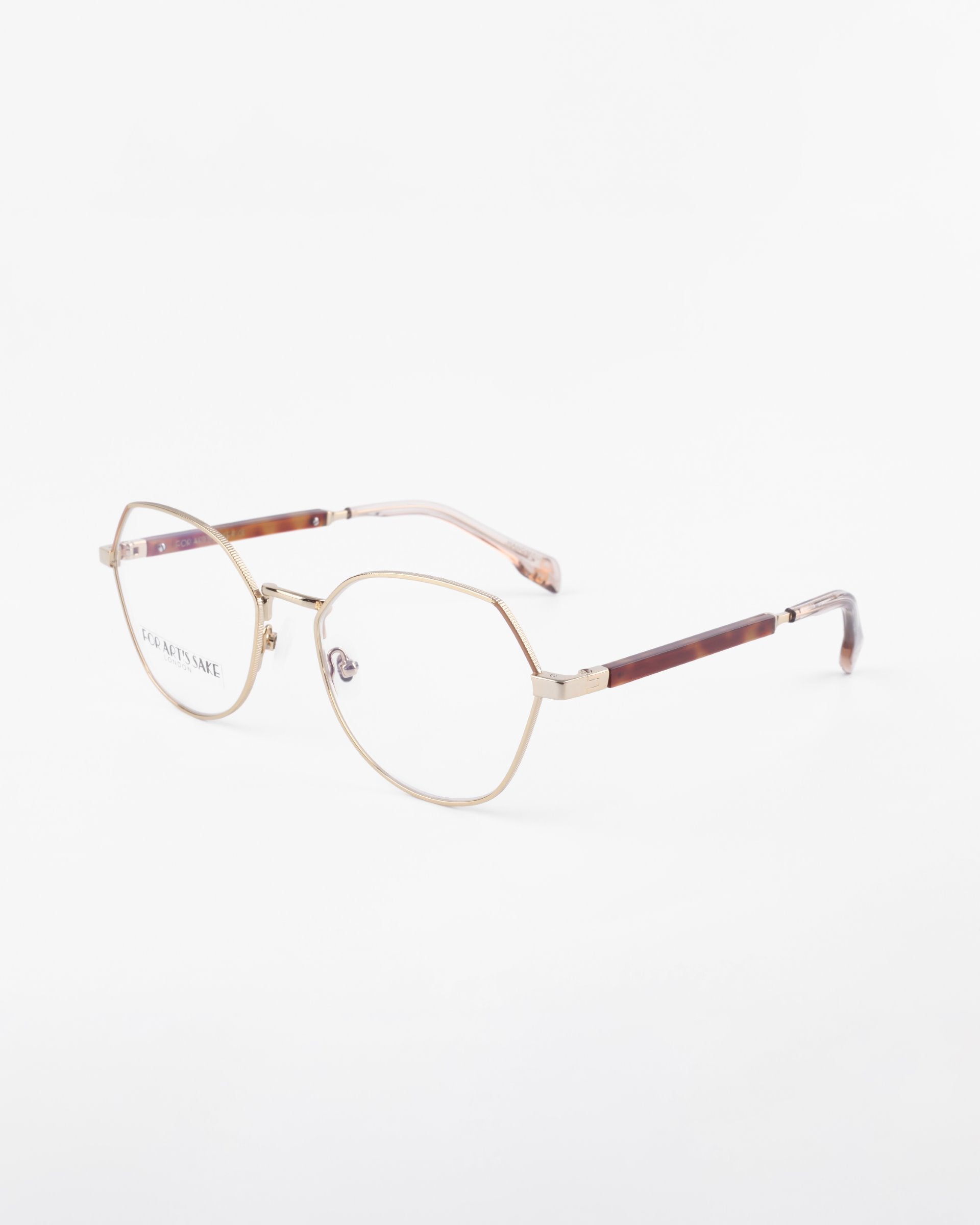 A pair of Orchard eyeglasses by For Art&#39;s Sake® featuring thin, 18-karat gold-plated metal frames. The temples are partly brown with a slightly translucent finish at the ends. The nose pads are clear, and the glasses are set against a white background.