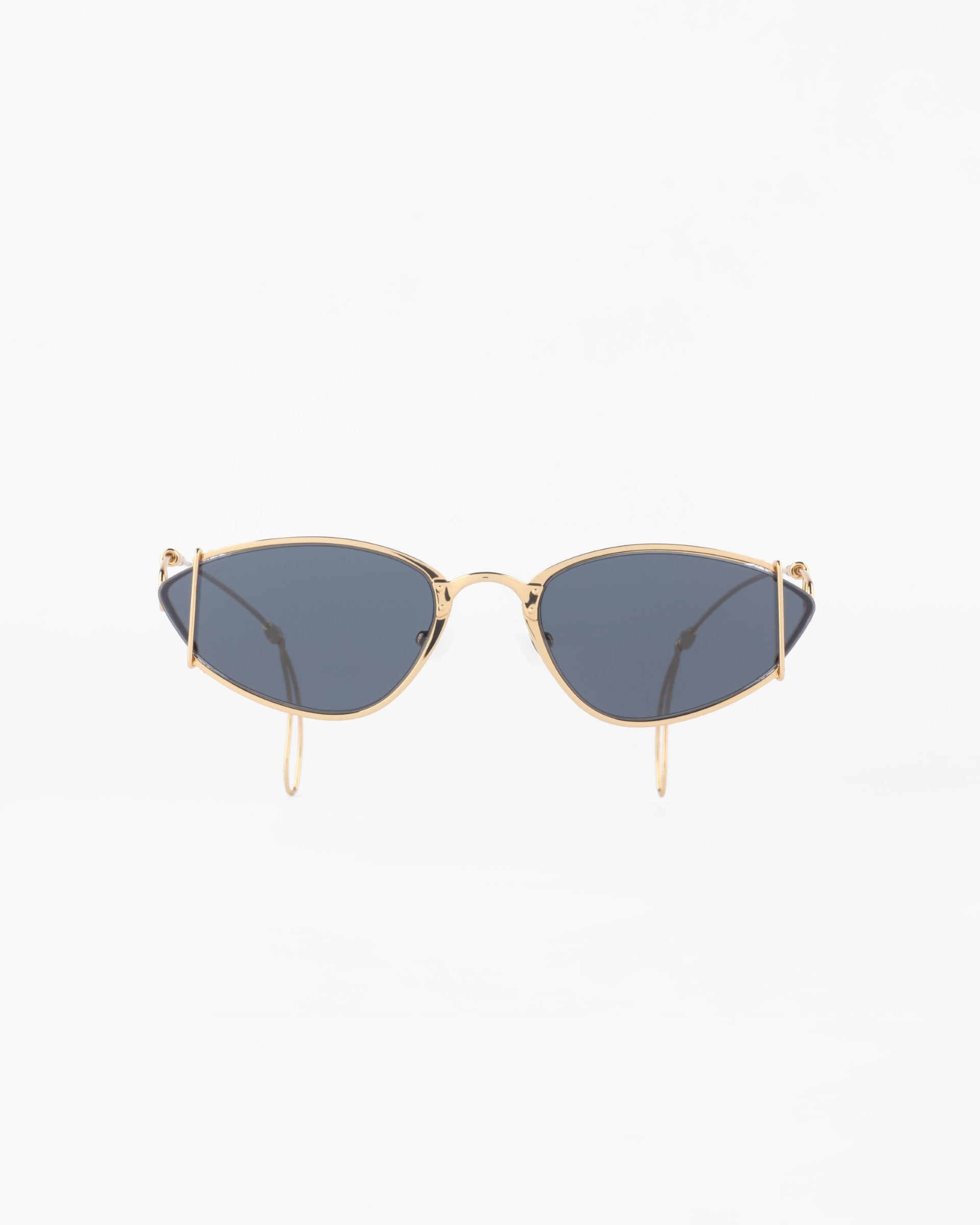 A pair of For Art's Sake® Ornate sunglasses with an 18-karat gold-plated metal frame and dark blue-tinted, ultra-lightweight nylon lenses. The design features a sleek, minimalist look with thin, curved arms and a slight cat-eye shape. Offering 100% UVA & UVB protection, the background is plain white.