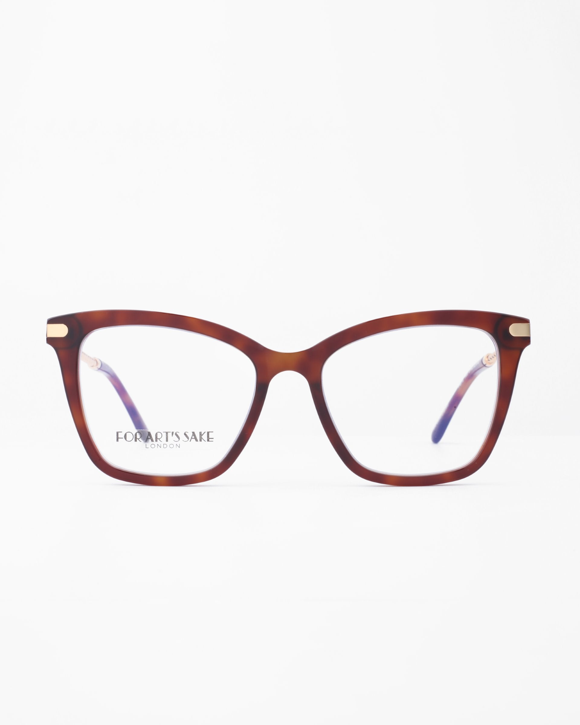 A pair of stylish, tortoiseshell pattern eyeglasses with a cat-eye shape. The frame features gold accents on the upper corners and the brand name &quot;For Art&#39;s Sake®&quot; is visible on one of the clear lenses. These chic Paris Two glasses also include a Blue Light Filter for added eye comfort. The background is white.