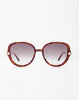 A pair of oversized, square-shaped Primrose sunglasses by For Art's Sake® with tortoiseshell frames made from plant-based acetate and gradient brown lenses is centered against a plain white background. Small handmade gold-plated accents are visible on the hinges where the temples meet the frame.