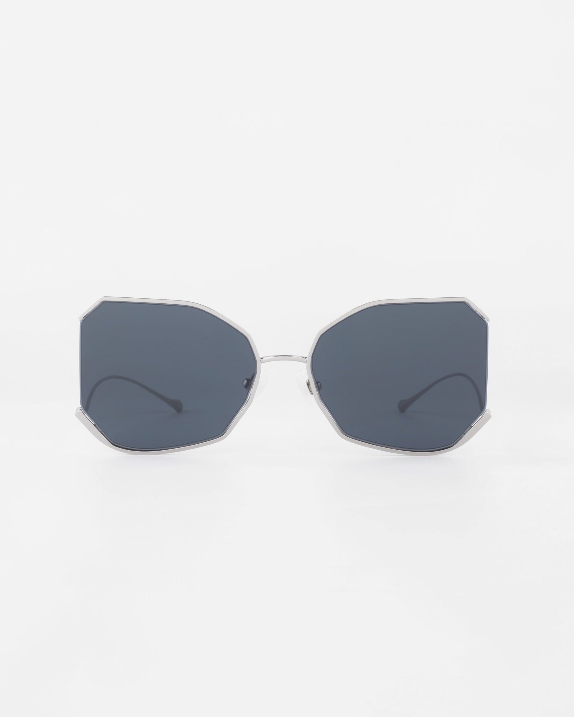 A pair of sunglasses with hexagonal-shaped, dark lenses and a thin, gold-plated stainless steel frame. The lightweight Nylon lenses offer UVA &amp; UVB protection. The background is white, and the &quot;Painter&quot; by For Art&#39;s Sake® sunglasses are centered in the image.