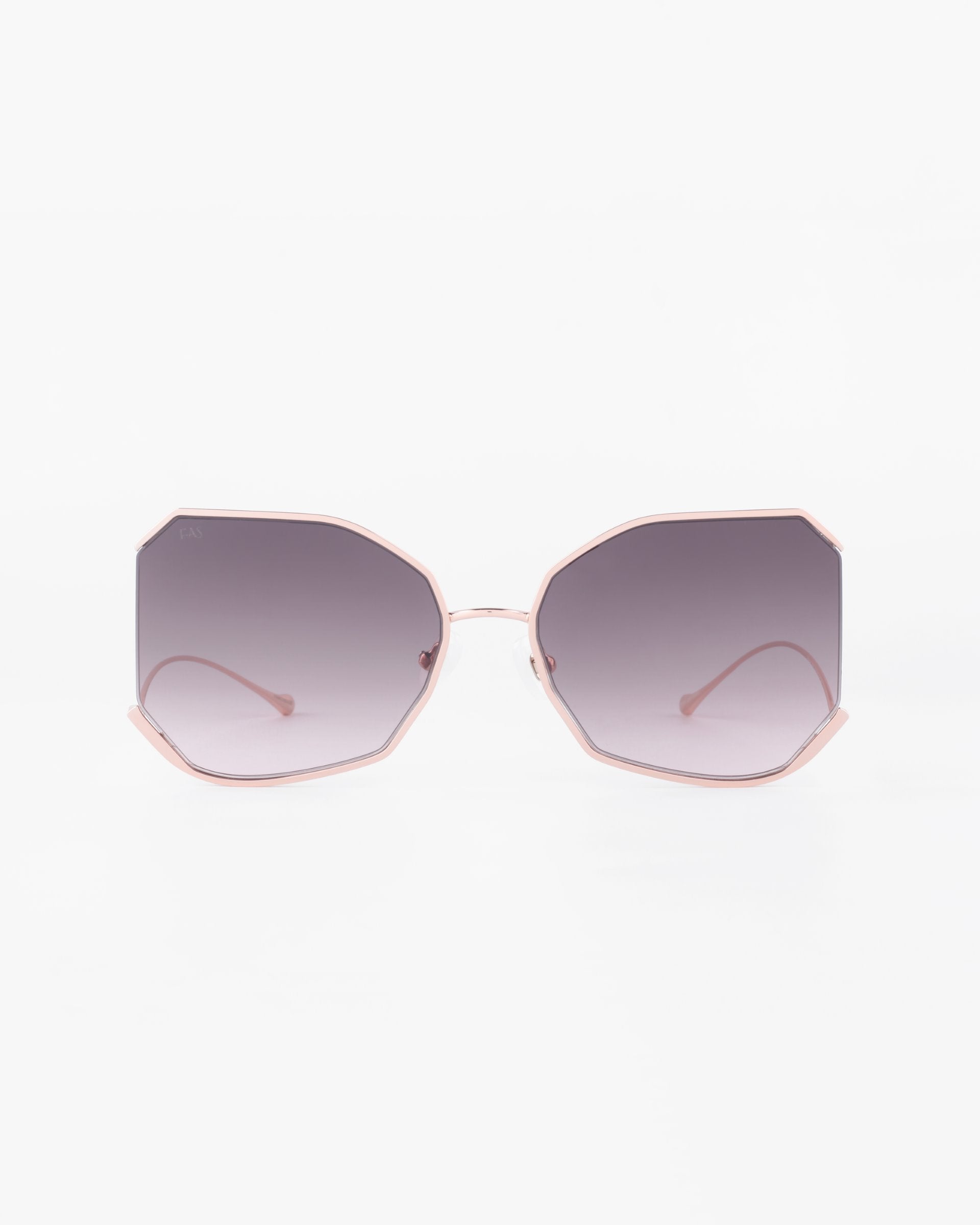 A pair of stylish For Art&#39;s Sake® Painter sunglasses with large, octagonal lenses that are tinted in a gradient from dark to light. Crafted with ultra-lightweight nylon lenses offering 100% UVA &amp; UVB protection, the thin gold-plated stainless steel frame and temples are a soft pink color, enhancing the contemporary and chic aesthetic. The background is plain white.