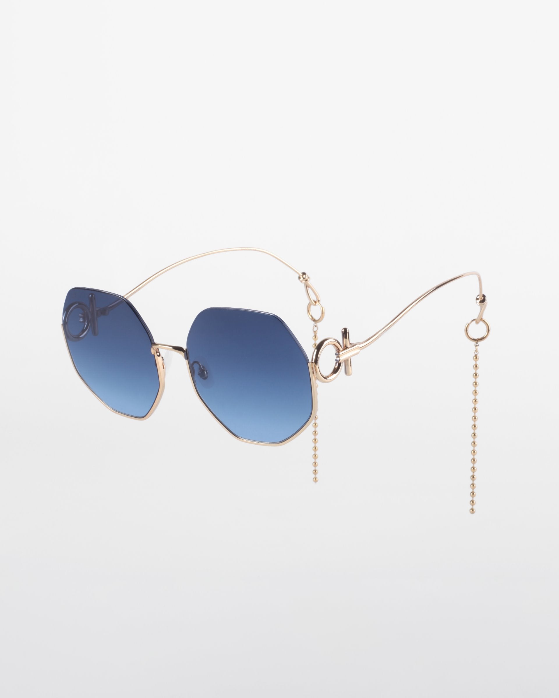 A limited edition pair of stylish sunglasses featuring blue-tinted hexagonal lenses, 18-karat gold-plated thin metal frames, and unique side arms with decorative chain accents. The background is plain white. The product name is &quot;Palace&quot; by For Art&#39;s Sake®.