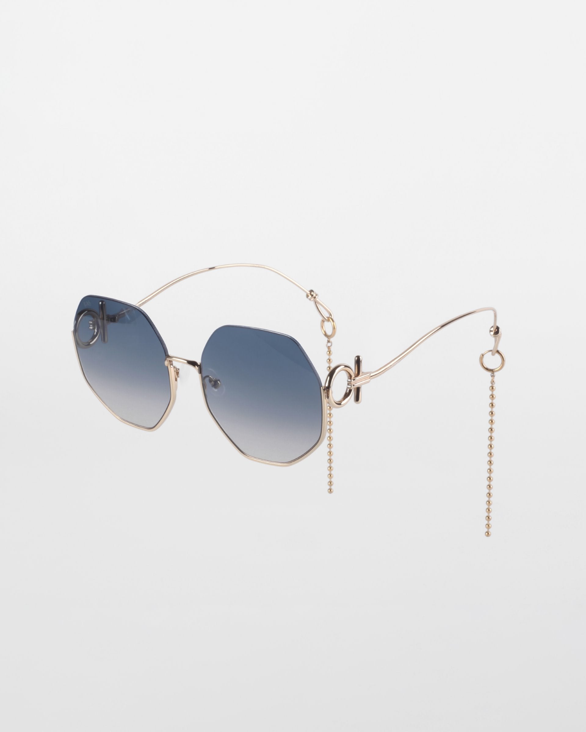 A pair of limited-edition fashionable Palace sunglasses by For Art&#39;s Sake® with blue gradient lenses and geometric, 18-karat gold-plated frames. The unique wireframe arms feature decorative chains hanging from the ends, adding an avant-garde touch to the design. These UVA &amp; UVB-protected Palace sunglasses are set against a plain white background.