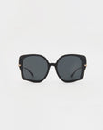 The Fahrenheit by For Art's Sake®: A pair of oversized square sunglasses with black frames and dark tinted lenses. These handmade acetate sunglasses feature thin 18-karat gold-plated accents on the outer sides of each lens, connecting to slender black arms. The background is plain white.