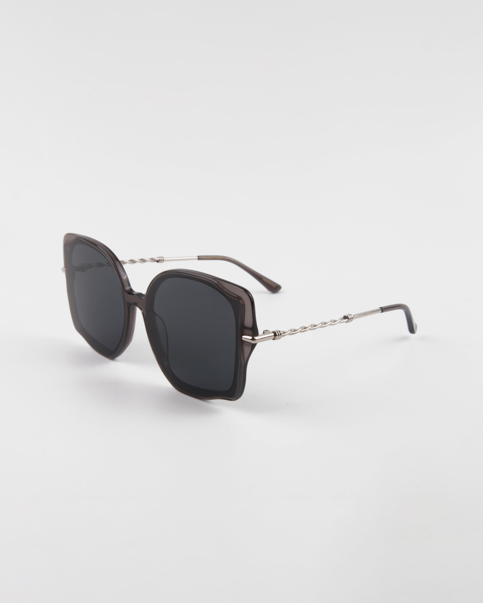 A pair of stylish, oversized square Fahrenheit sunglasses with dark lenses and thin, intricate 18-karat gold-plated arms by For Art's Sake®, isolated on a white background.