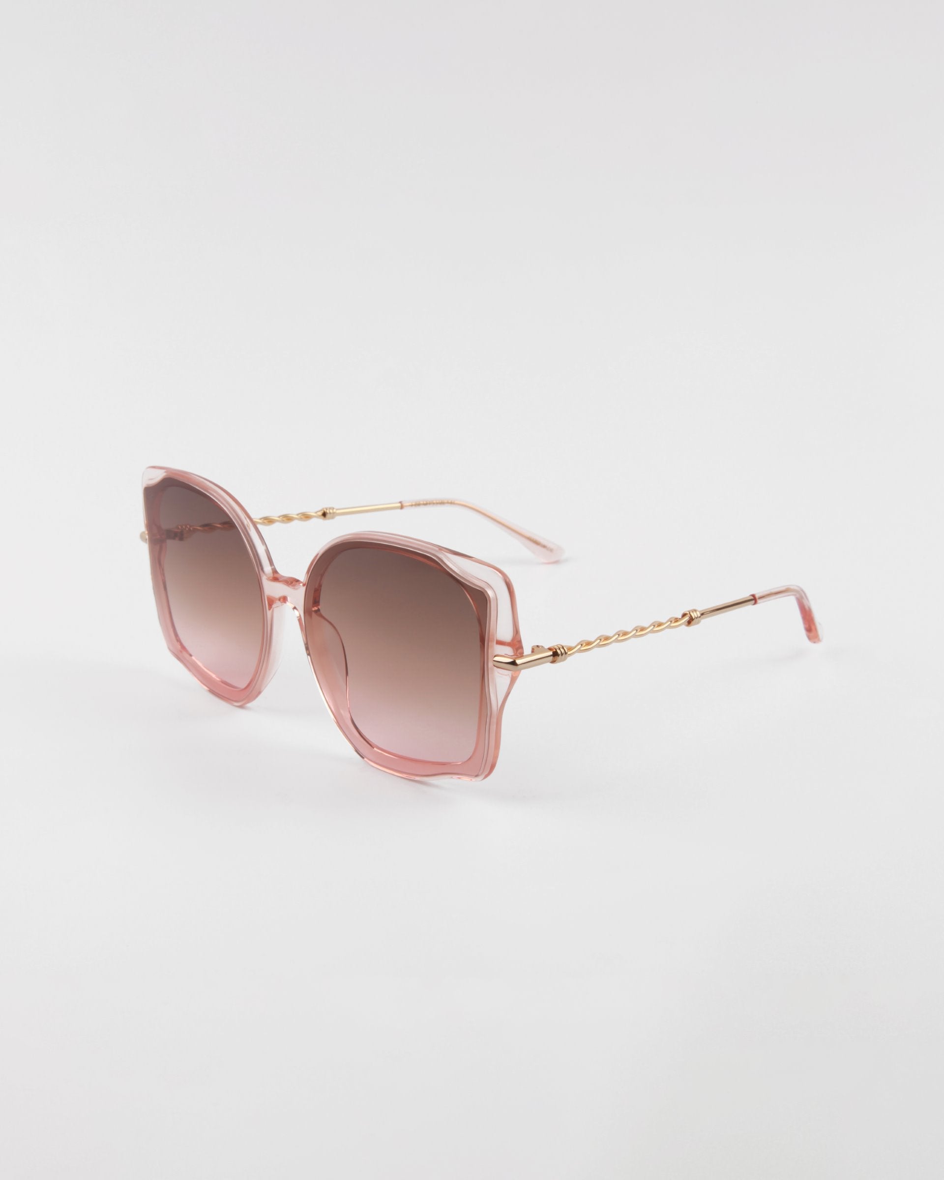 Square-shaped, oversized frame Fahrenheit sunglasses by For Art&#39;s Sake® with pink gradient lenses and a light pink metal frame, featuring thin 18-karat gold-plated arms with a chain-like design. The Fahrenheit sunglasses by For Art&#39;s Sake® are placed on a plain white background.