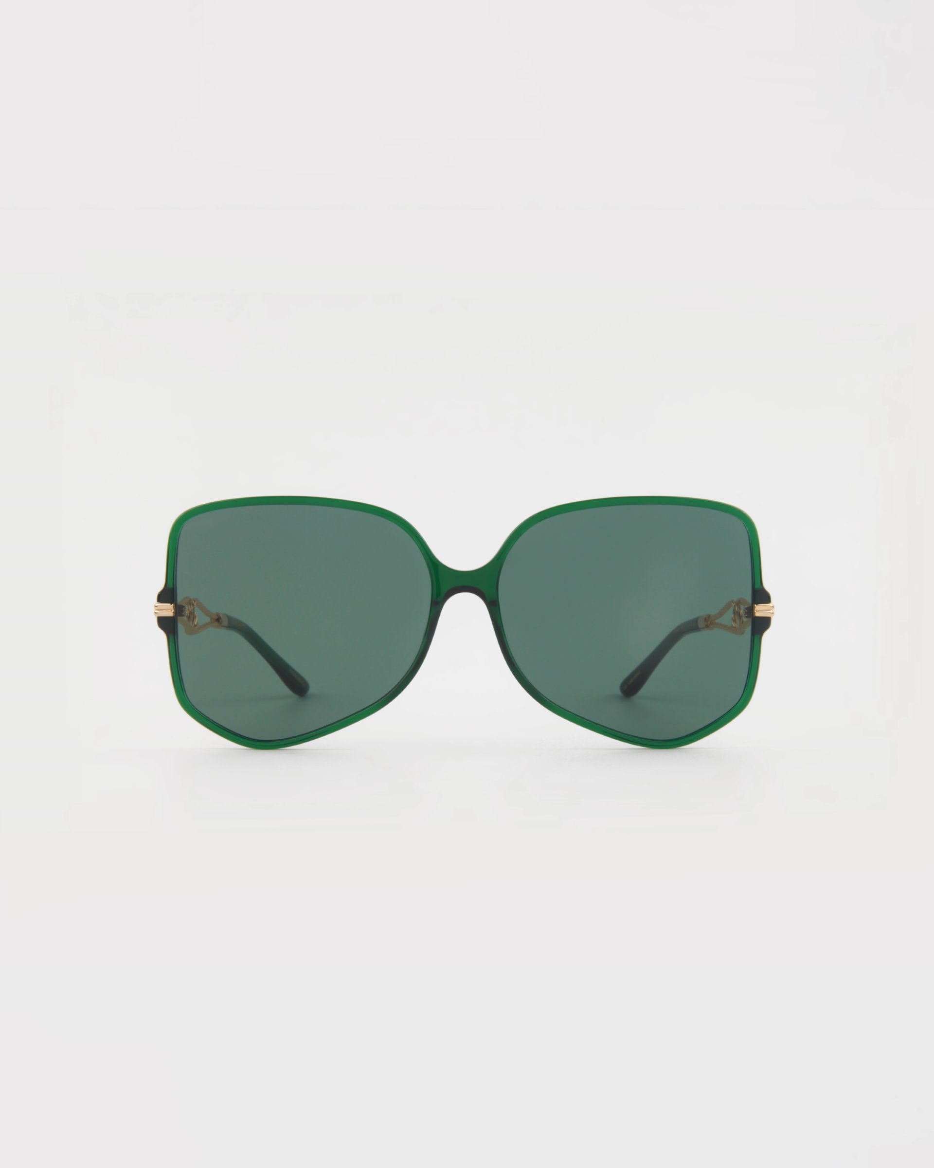 A pair of oversized, square-shaped sunglasses with dark green lenses and handmade acetate green frames is centered on a plain white background. The Voyager sunglasses by For Art's Sake® have black arms, gold accents on the hinges, and offer UVA & UVB protection.