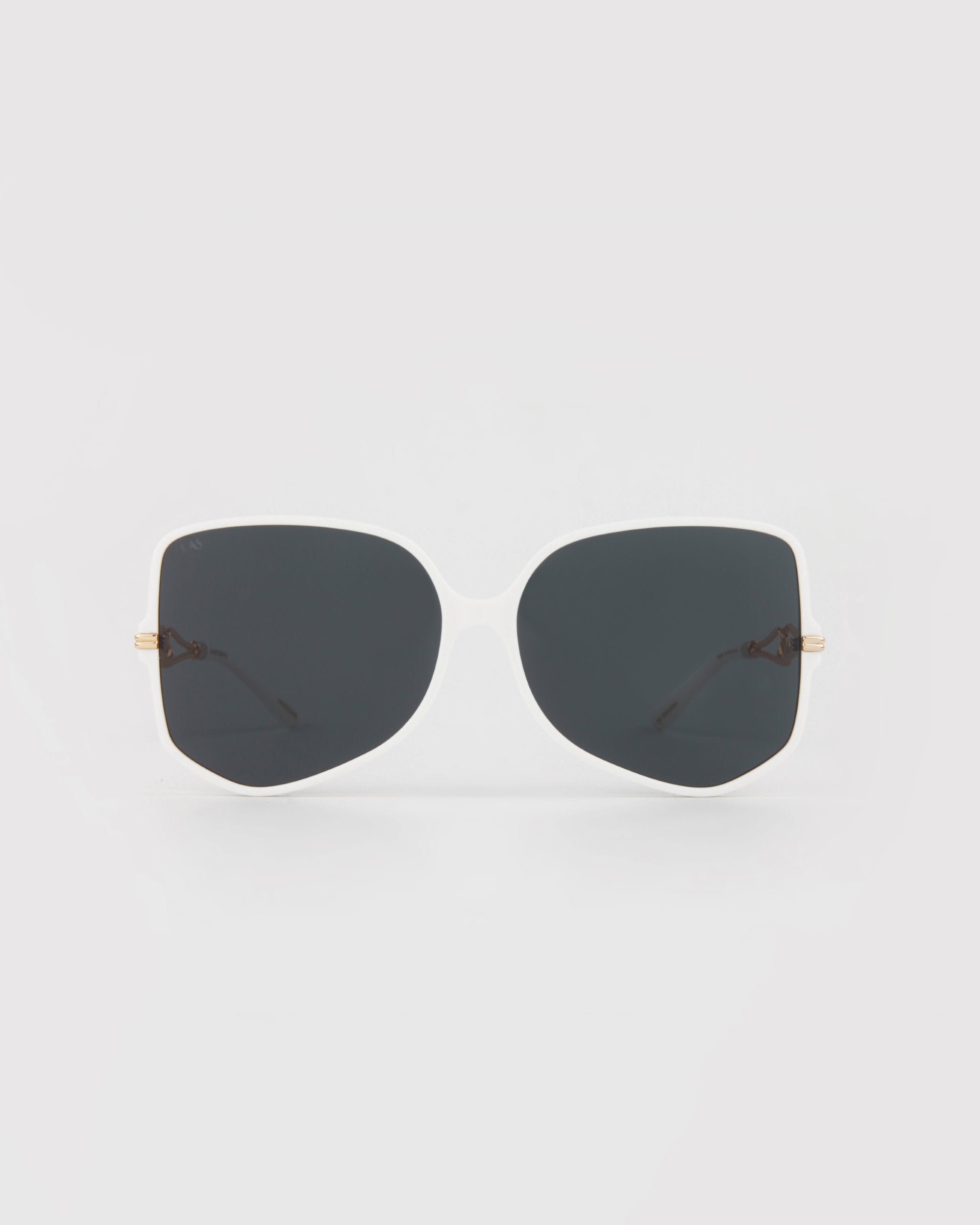 A pair of oversized, square-shaped sunglasses featuring white frames and black lenses. With thin, gold-plated arms and dark-colored temple tips, these minimalistic and modern Voyager by For Art's Sake® sunglasses offer stylish excellence. Perfectly crafted from handmade acetate eyewear, they provide both UVA & UVB protection.