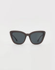 A pair of black For Art's Sake® Ice Cream sunglasses with dark tinted lenses, viewed from the front. The sunglasses have a sleek, matte finish with small metal stud details near the hinges on the corners of the frames. Handmade acetate cat-eye frames ensure both style and quality, set against a plain white background.