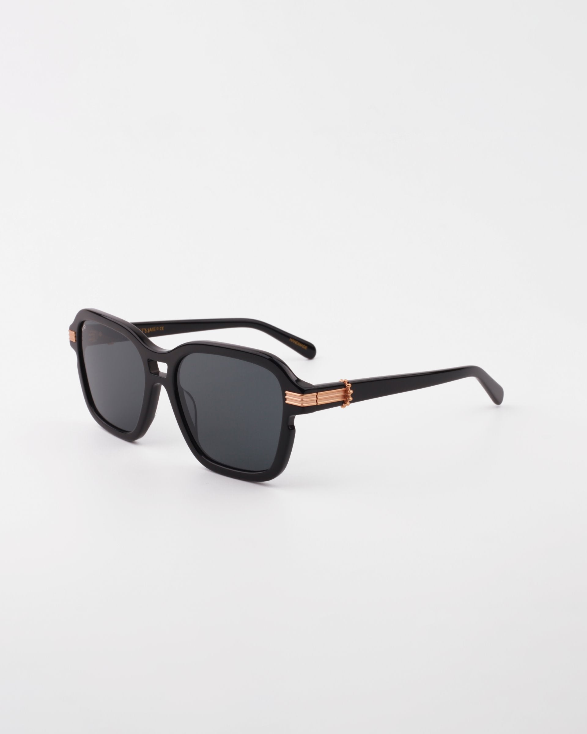 A pair of black Shadyside by For Art&#39;s Sake® with rectangular frames and shatter-resistant nylon lenses sits against a plain white background. The Shadyside feature gold-plated temple details for an added touch of style.