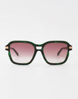 The Shadyside sunglasses from For Art's Sake® feature large, square lenses with a stylish gradient-tinted pink hue that offers UVA & UVB protection and fades elegantly from dark to light. The dark frame is adorned with green striations, while the temples include chic metallic accents near the hinges. Handcrafted from acetate, these sunglasses stand out beautifully against a plain white background.
