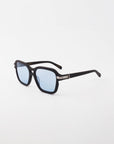 A pair of Shadyside sunglasses by For Art's Sake® boasts black, rectangular handmade acetate frames with light blue lenses, elegantly displayed on a white background. The temples are adorned with an 18-karat gold-plated decorative accent near the hinges, offering both style and comprehensive UVA & UVB protection.