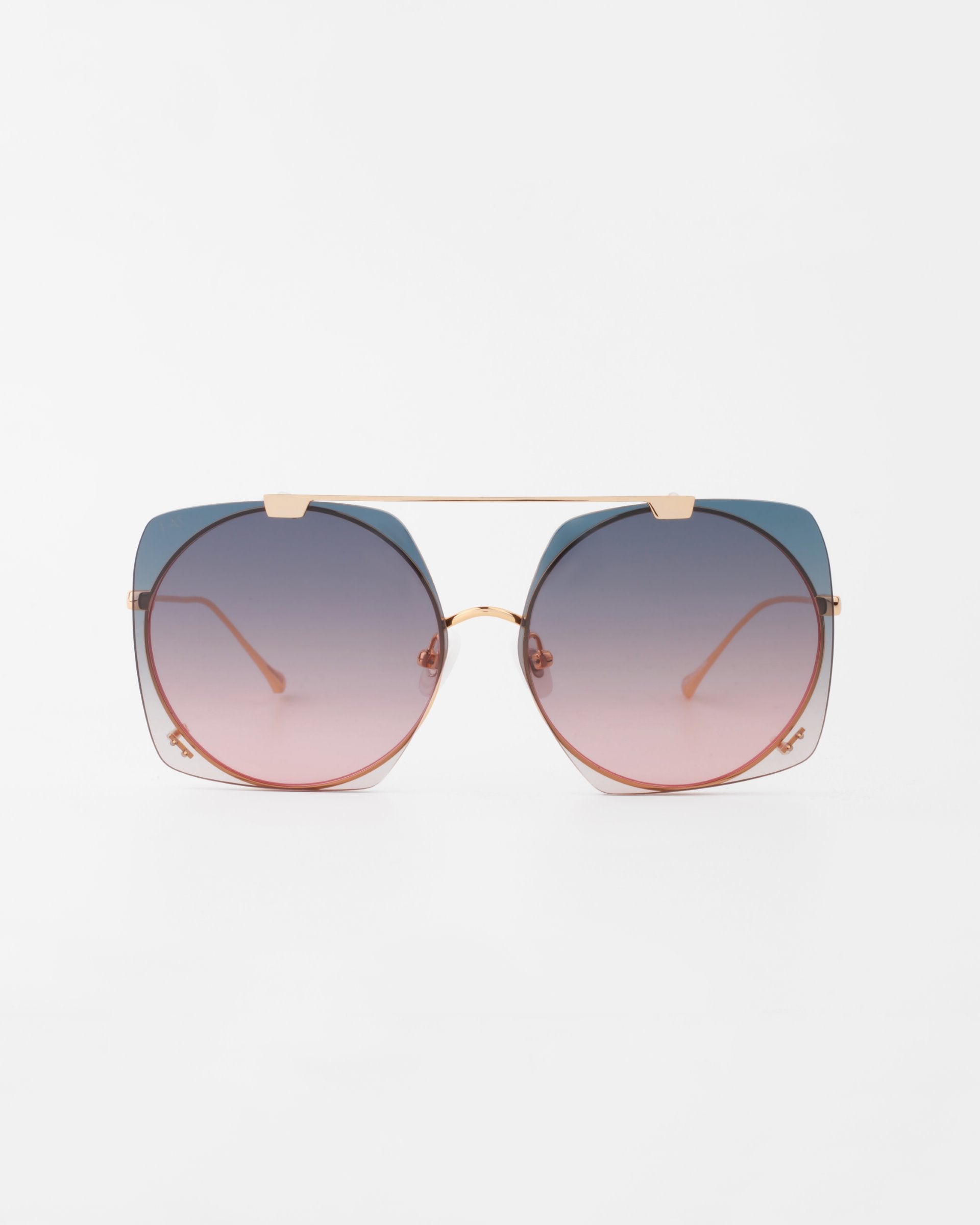 A pair of oversized, square-shaped Last Summer sunglasses by For Art&#39;s Sake® with gradient lenses, transitioning from dark blue at the top to light pink at the bottom. The glasses feature a thin, 18-karat gold-plated metal frame and a double bridge design, providing complete UVA &amp; UVB protection.