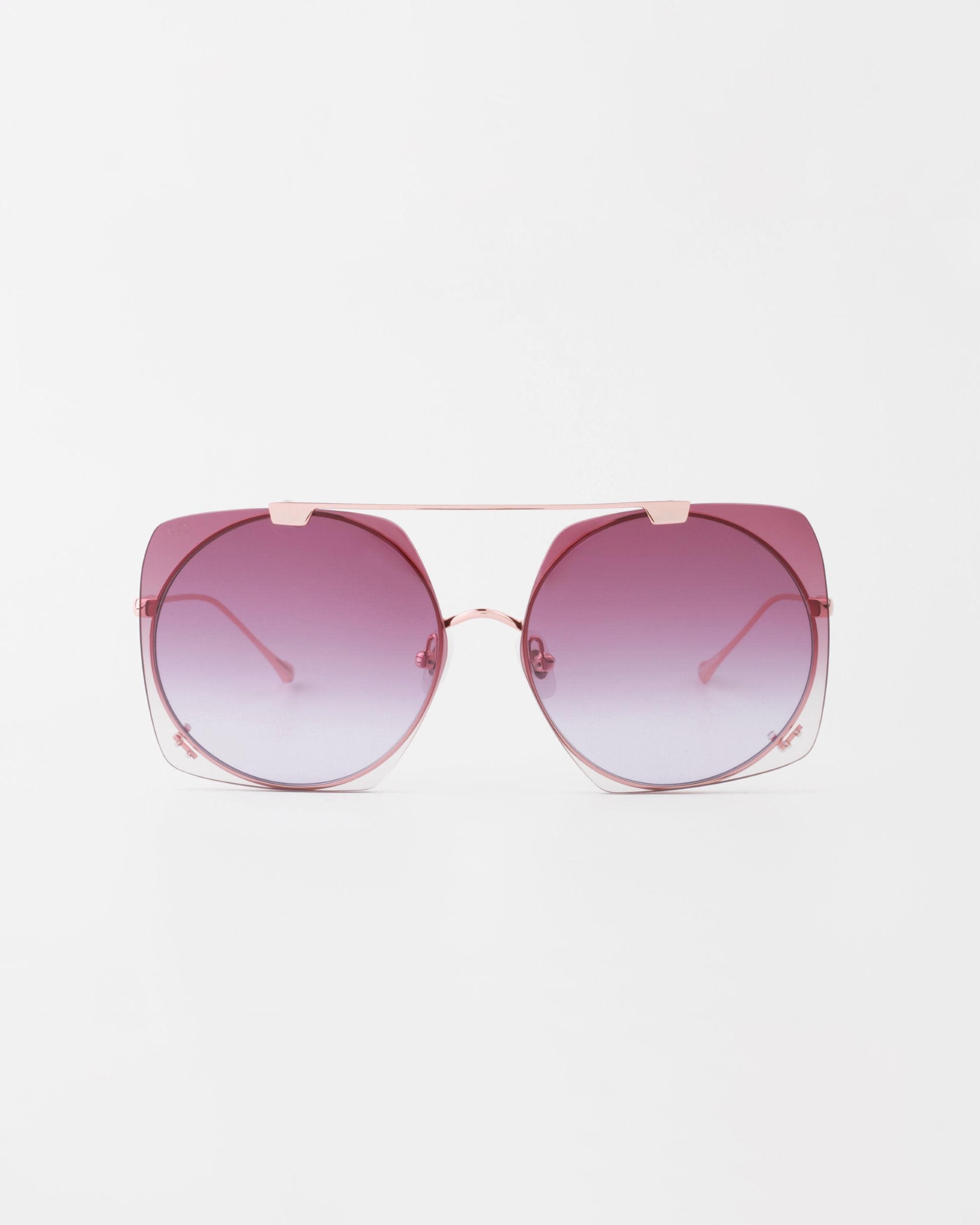 A pair of oversized, square sunglasses with a thin, 18-karat gold-plated frame. The lenses are gradient, shading from a dark pink at the top to a lighter pink at the bottom. The slim temples feature a subtle curve. These UVA & UVB-protected shades, For Art's Sake® Last Summer, are set against a plain white background.