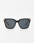 A pair of handmade Gaia - Champagne sunglasses by For Art's Sake® is shown against a plain white background. The black rectangular frames feature dark lenses, thin arms, and small 18-karat gold-plated accents on the hinges.