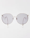 A pair of For Art's Sake® Birthday Cake silver-framed sunglasses with round, dark-tinted lenses. The temples feature a unique design with looped wire and small, pearl-like accents at the tips. Lightweight shatter-resistant lenses ensure durability and comfort. The background is plain white.