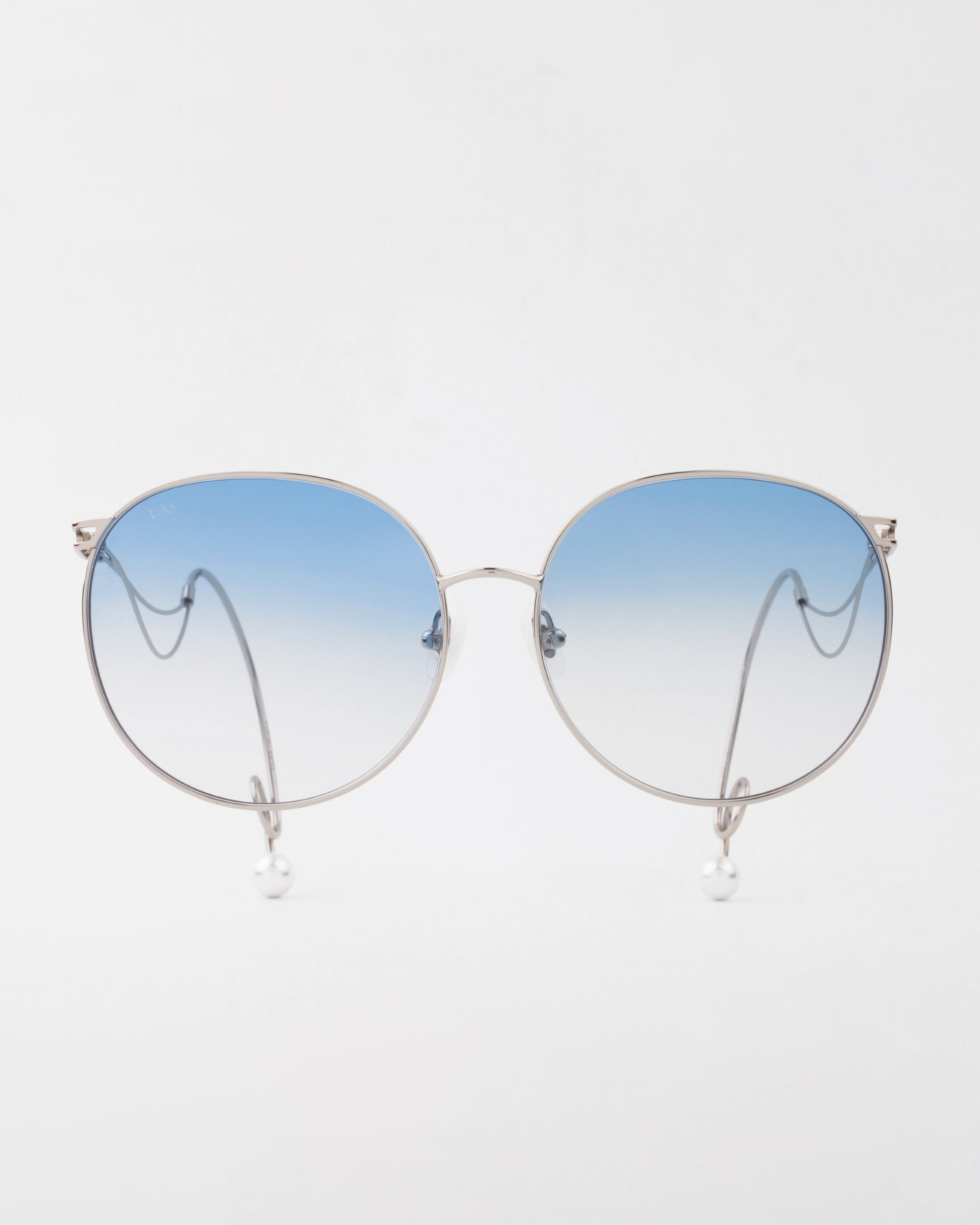 A pair of round For Art&#39;s Sake® Birthday Cake sunglasses with a thin, handmade gold-plated frame and blue gradient, lightweight shatter-resistant lenses. The temples have pearl accents at the ends, and the glasses are set against a plain white background.