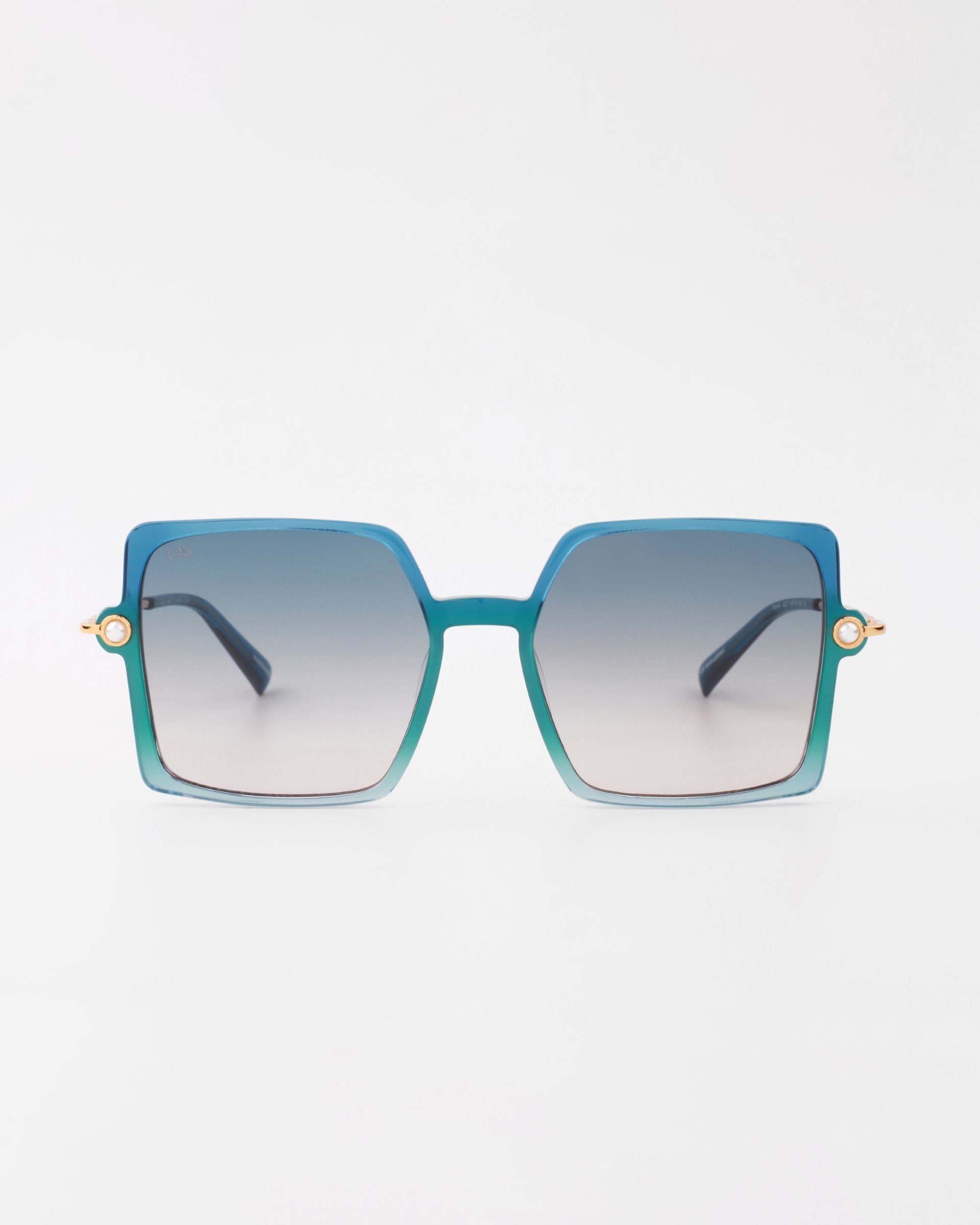A pair of stylish handmade acetate sunglasses with gradient blue square lenses and thin 18-karat gold-plated arms on the sides. The frame transitions from blue at the top to a lighter shade at the bottom, offering complete UVA &amp; UVB protection against harmful rays. The product is called Moxie by For Art&#39;s Sake®. The background is plain white.