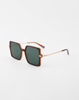 A pair of Moxie by For Art's Sake® handmade acetate sunglasses with square, green-tinted lenses. The frame is brown, and the temples are 18-karat gold-plated with a thin, chain-link design and brown tips. Complete with UVA & UVB protection, these Moxie sunglasses are positioned on a white background.