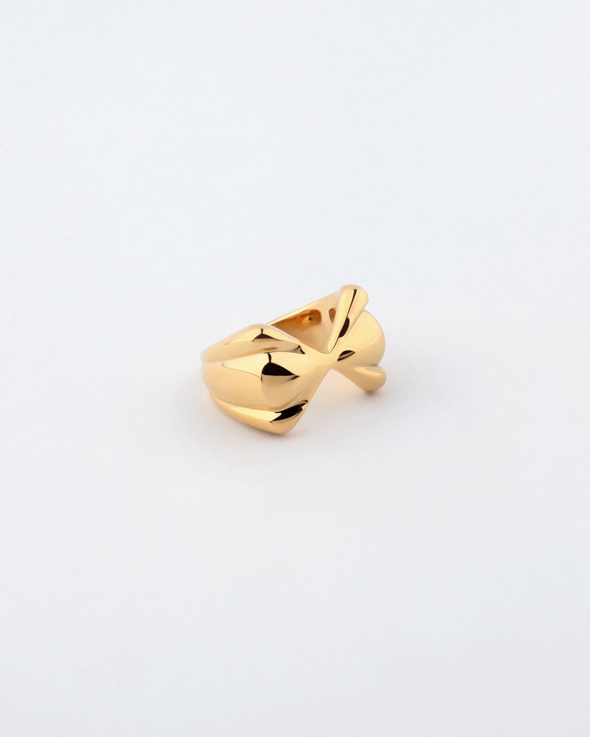 A close-up of the For Art&#39;s Sake® Sydney Ring, showcasing its modern, geometric design. The gold-plated ring features overlapping and interlocking gold strands, creating a bold and artistic appearance with a hint of a bow-shaped design. The plain white background makes the Sydney Ring stand out prominently.