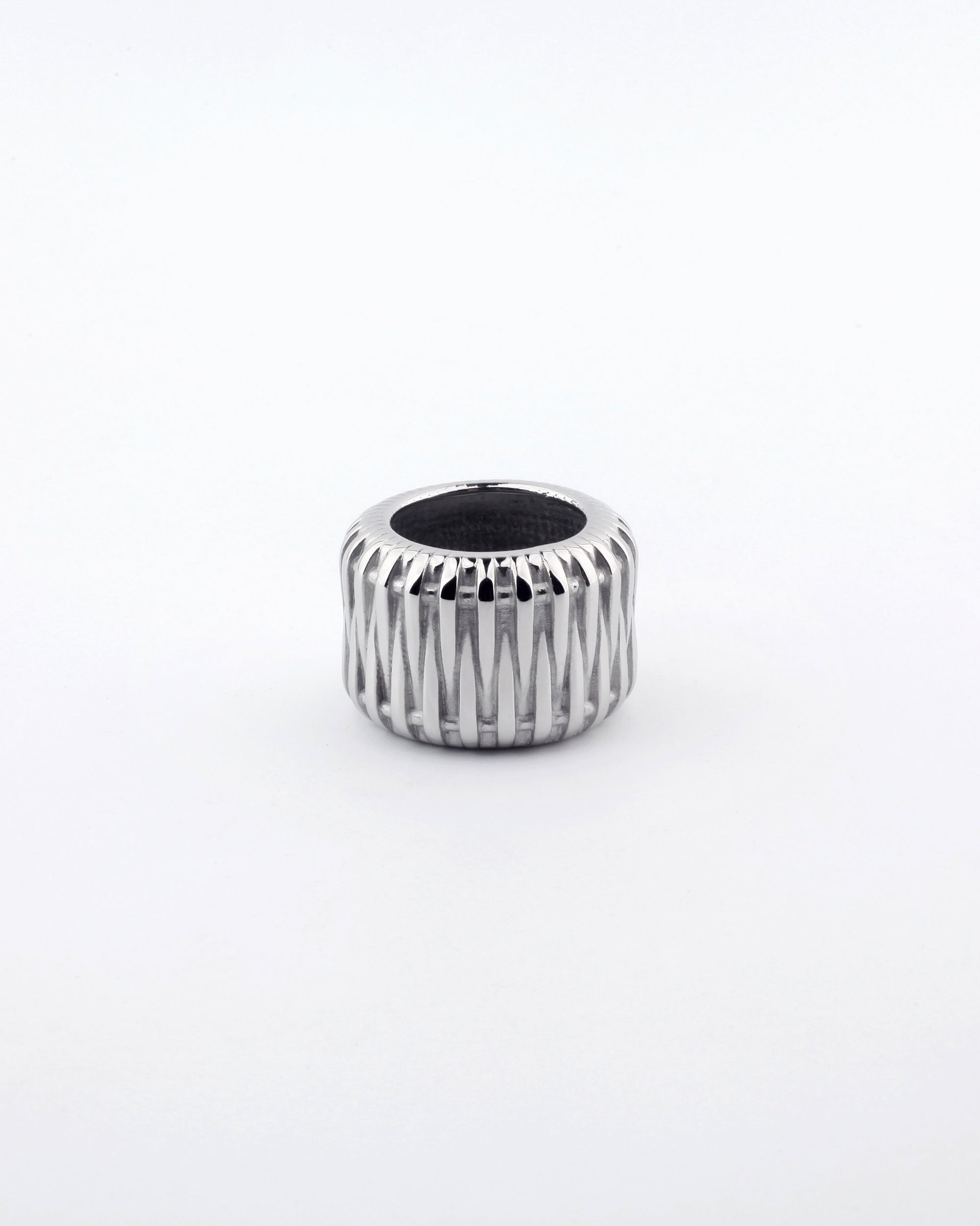 A silver metallic Woven Ring from For Art's Sake®, featuring a textured crisscross pattern design, displayed against a plain white background. The wide band ring showcases a slightly dark inner surface.