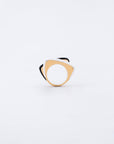 The Delta Ring by For Art's Sake®, a minimalist, modern piece with a geometric design, is showcased against a plain white background. It features a triangular shape with rounded edges, combining silver and gold tones and boasts a unique layered design accentuated by a bold splash of color along its inner side.