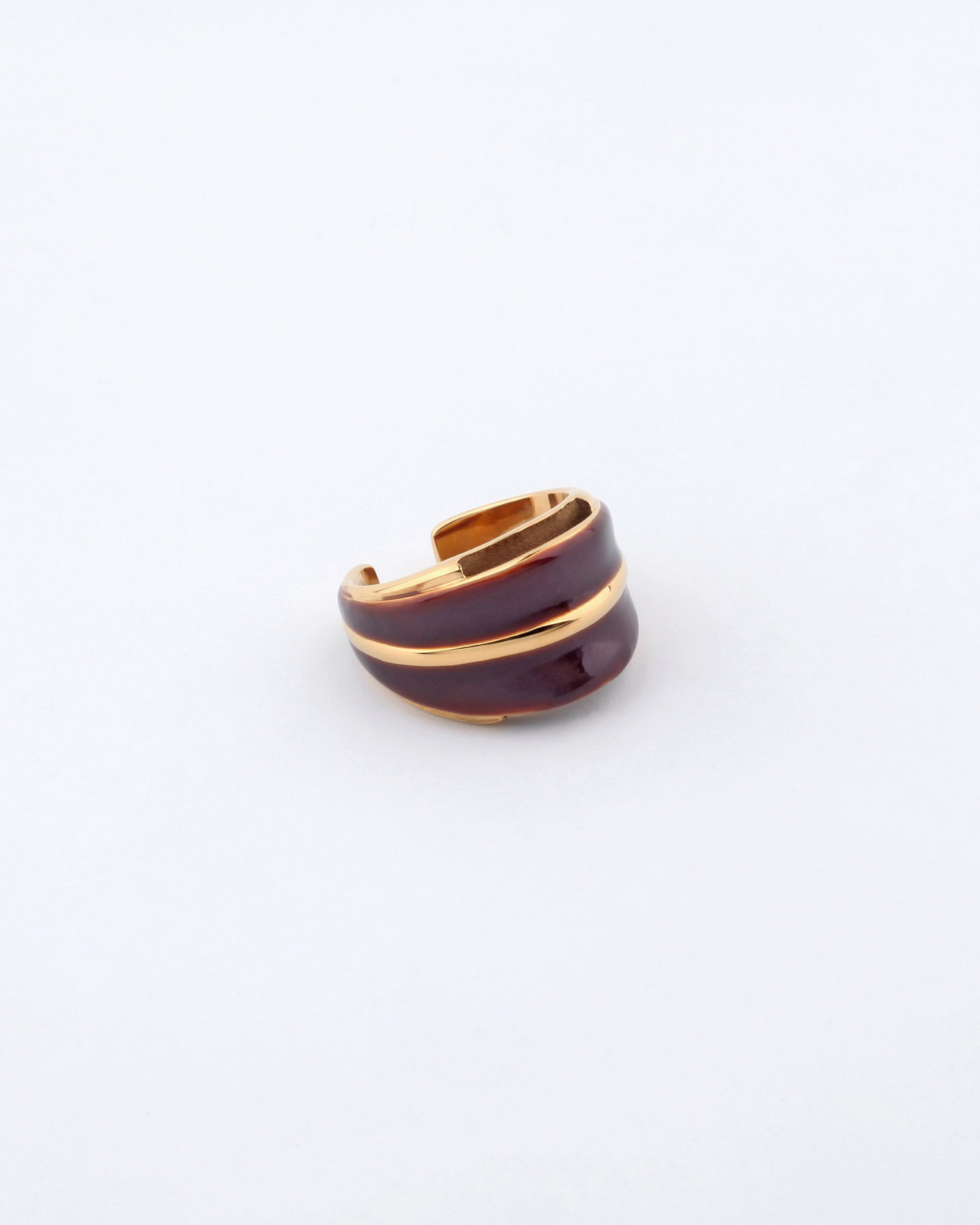 The Maven Ring by For Art's Sake® is a stylish, two-tone piece featuring a gold and dark brown design. Its smooth, wavy pattern is perfectly showcased on a light gray background. The open-ended versatile design exudes sophisticated elegance and contemporary allure.