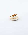 The Maven Ring from For Art's Sake® is an elegant jewelry piece with an overlapping band design. Featuring a smooth finish and sections of white enamel contrasted by gold-toned accents, it offers a stylish and contemporary look. The plain white background accentuates its exquisite details perfectly.