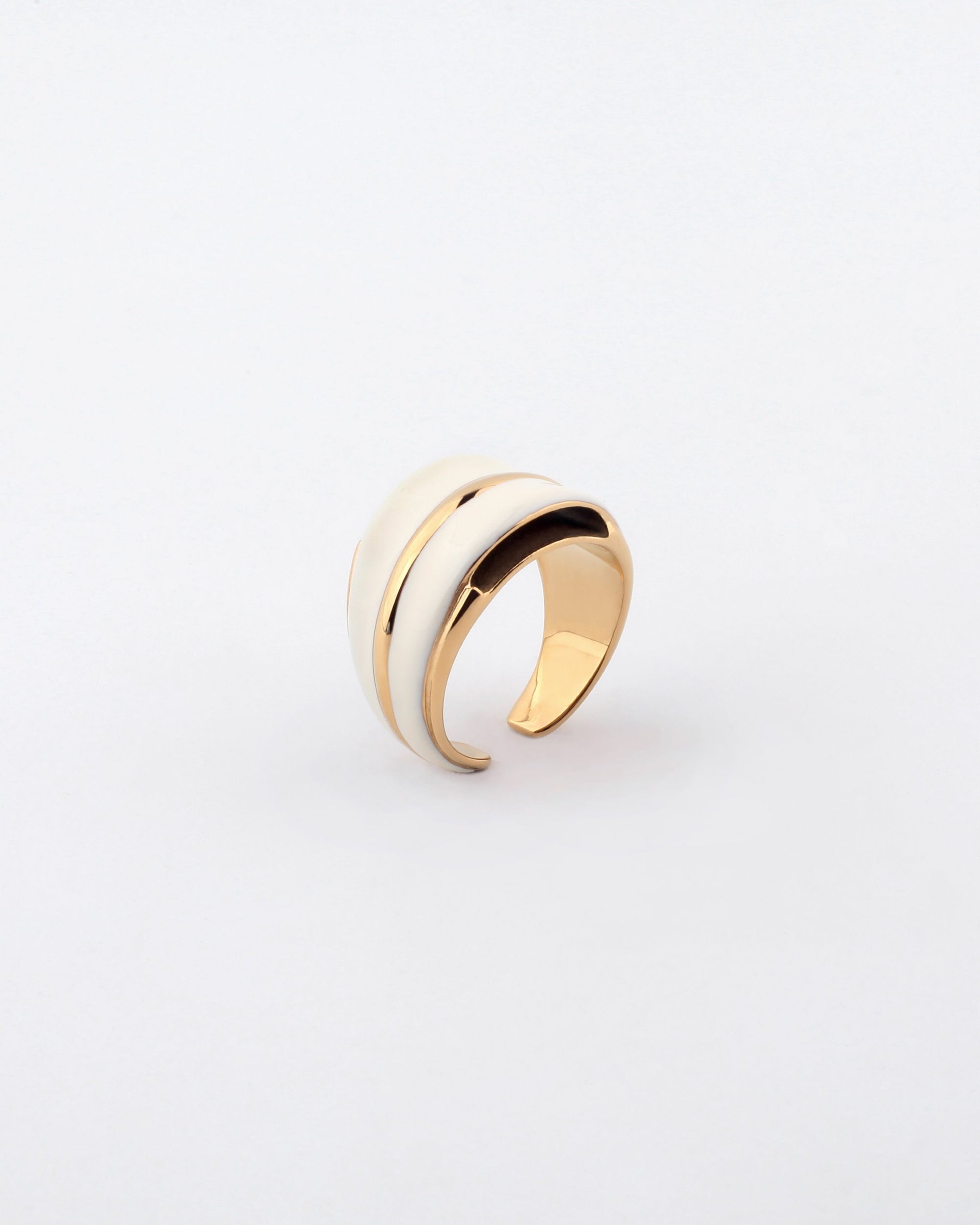 The Maven Ring by For Art's Sake® is a gold-toned ring distinguished by its smooth, wide band design and an elegant white inlay stripe running along the top. Its sleek and modern appearance is beautifully complemented by the plain white background, while the gold-toned metal accents add to its sophisticated look.