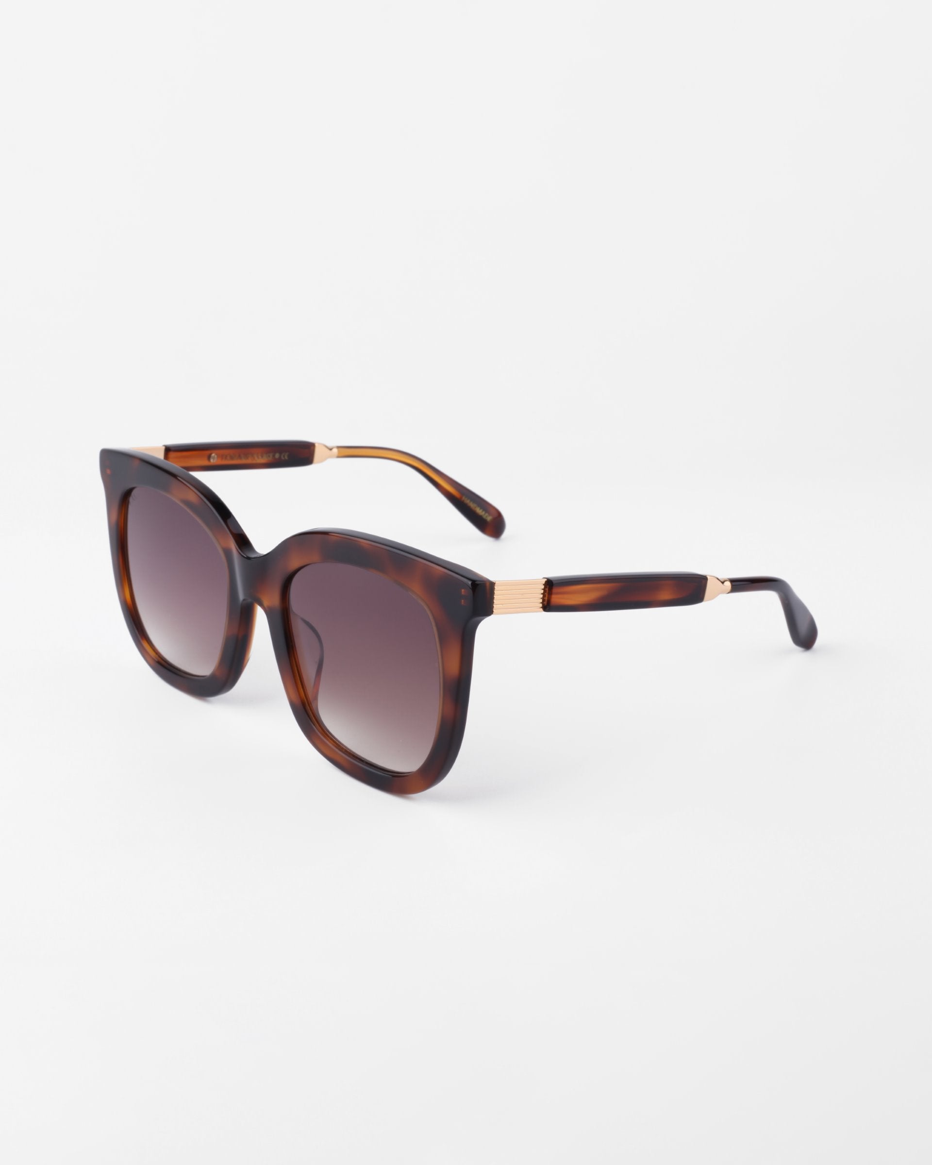 A pair of Riverside square-shaped, dark-tinted sunglasses with a handmade acetate tortoise shell pattern frame and gold-plated detailing on the arms by For Art&#39;s Sake®, displayed against a plain white background.