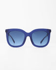 A pair of For Art's Sake® Riverside square-shaped sunglasses with a blue frame and blue-tinted, shatter-resistant lenses is centered against a white background. The sunglasses have a minimalist and modern design.