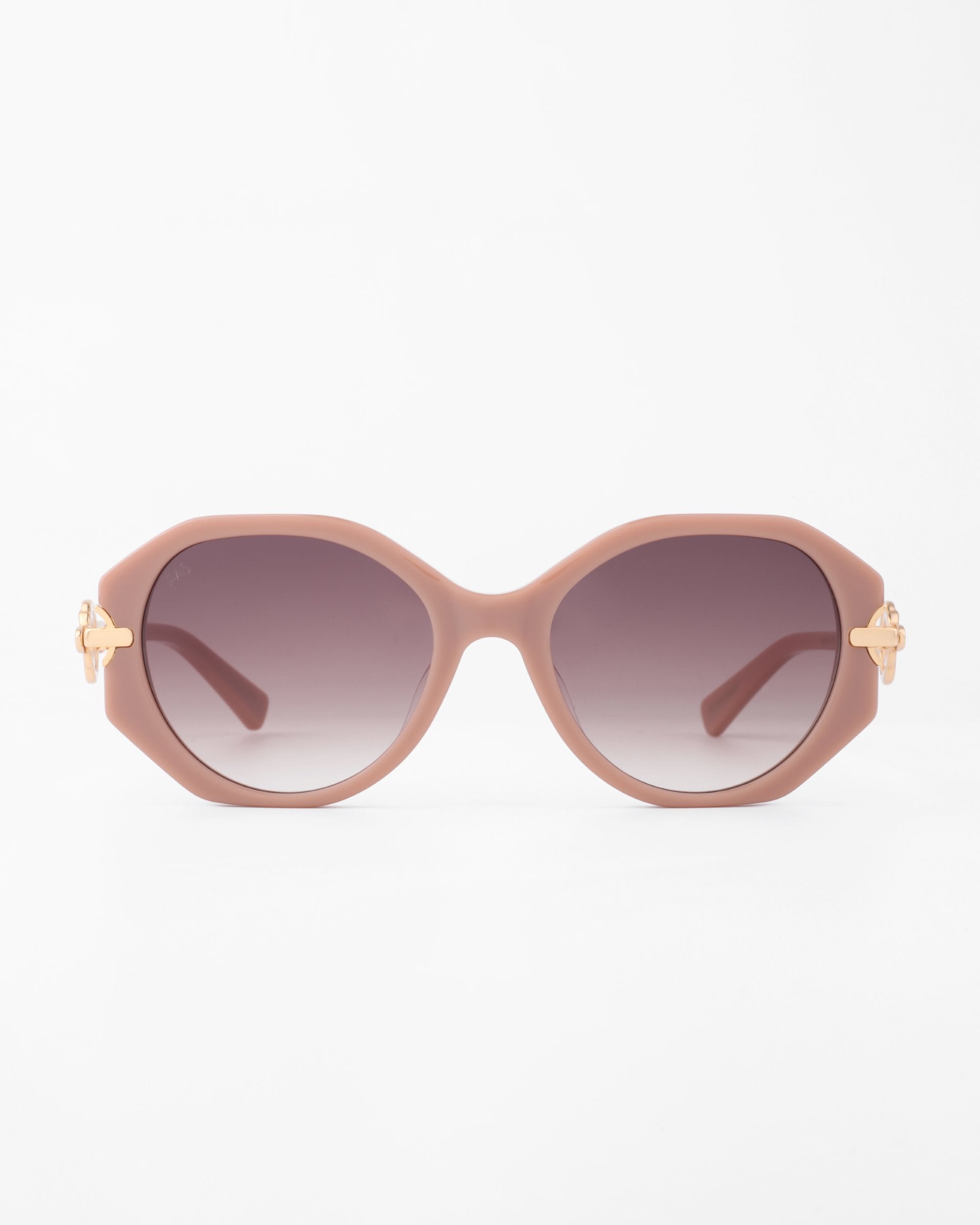 A pair of oversized, rounded sunglasses with light pink, handmade acetate frames and gradient dark lenses. The temples are adorned with gold-plated detailing on each side, adding a touch of elegance to the design. This is the For Art&#39;s Sake® Seaside model. The background is plain white.