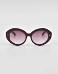 A pair of round, oversized Helios sunglasses with dark purple frames and gradient lenses transitioning from dark at the top to light at the bottom by For Art's Sake®. This piece of luxury eyewear is set against a plain white background.