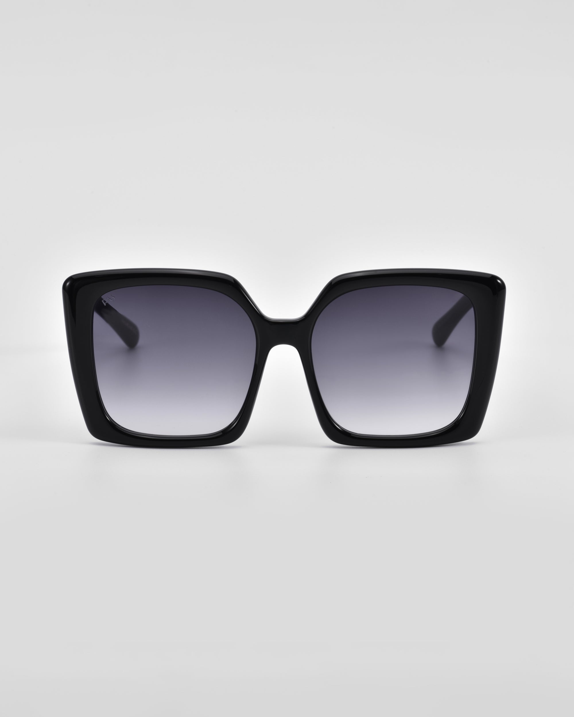 A pair of black oversized square Eos sunglasses with dark tinted lenses and classic temple round details by For Art&#39;s Sake®. The glasses are facing forward, showcasing the full frame and lens design against a plain white background.