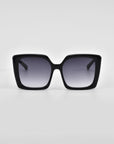 A pair of black oversized square Eos sunglasses with dark tinted lenses and classic temple round details by For Art's Sake®. The glasses are facing forward, showcasing the full frame and lens design against a plain white background.