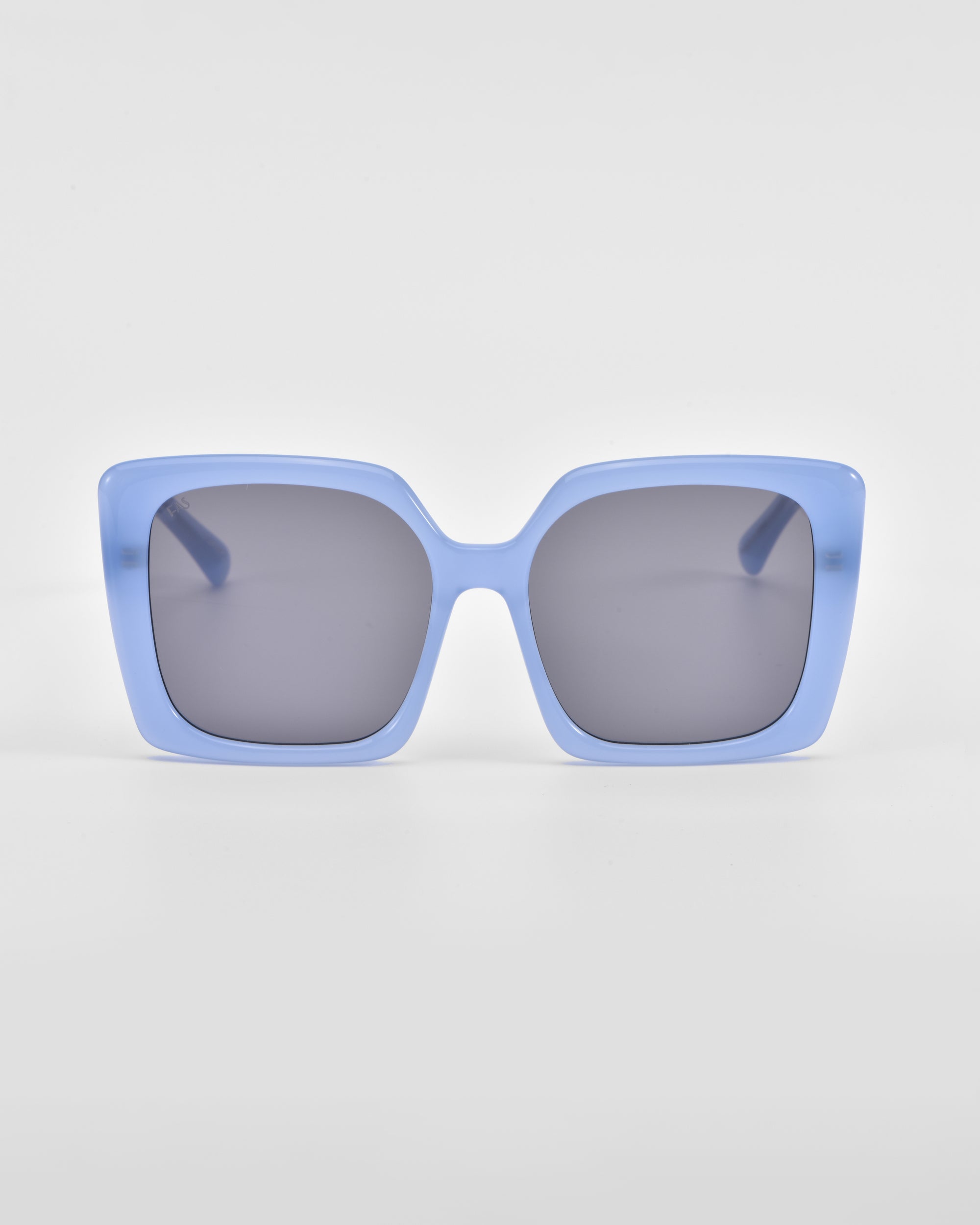 A pair of oversized, square For Art&#39;s Sake® Eos sunglasses with light blue frames and dark lenses against a white background.