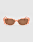 A pair of chic Mene cat-eye sunglasses by For Art's Sake® features peach-colored frames and brown tinted lenses, set on a light gray background.