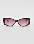 A pair of Mene sunglasses by For Art's Sake® with a brown, glossy frame and rectangular lenses that have a subtle pinkish tint. The arms of the glasses are obscured but appear to match the frame in color. White background.